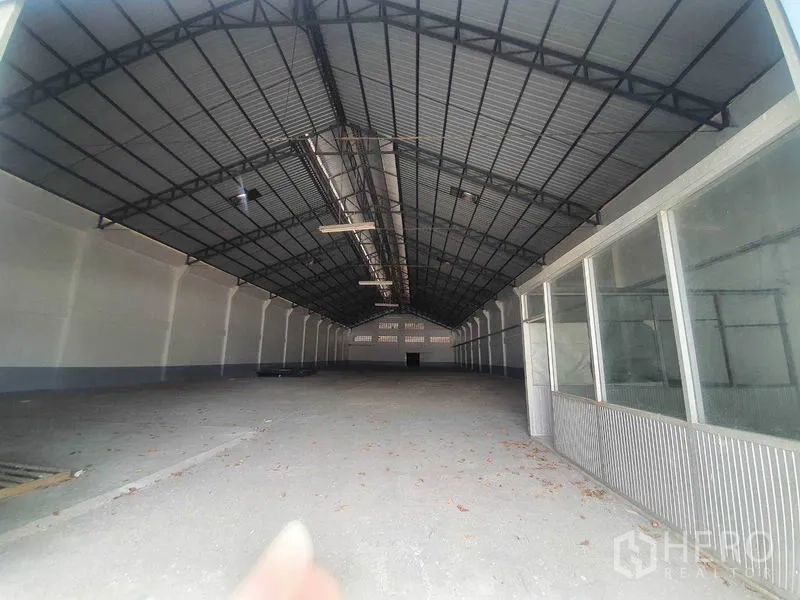 Warehouse for rent in Nakhon Pathom - Spacious warehouse interior with high steel truss roof and open column-free floor.