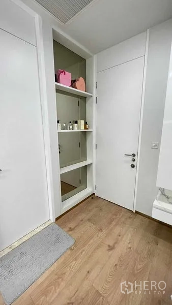 Condominium for rent in Watthana, Bangkok - Entry niche shelving with white doors and warm wood flooring.