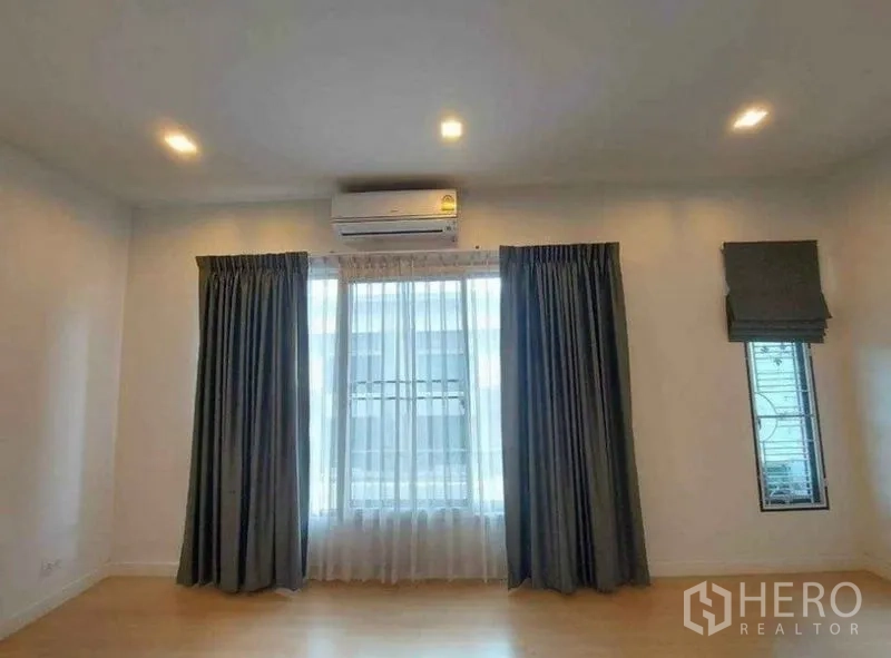 Townhouse for rent in Bang Phli, Samut Prakan - Spacious bedroom with split air-conditioner, recessed lights and large curtained windows.