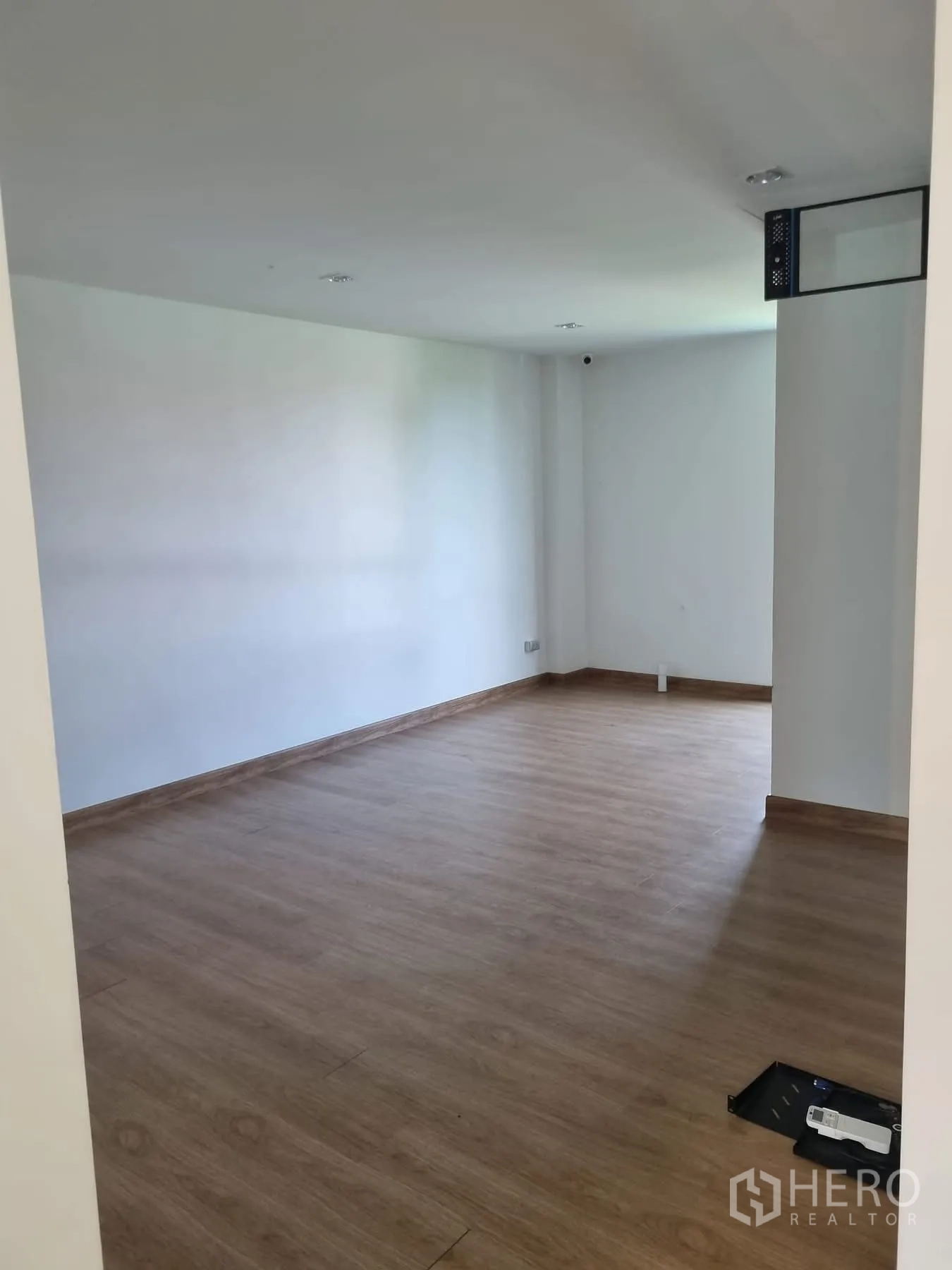 Home Office for rent in Khlong Toei, Bangkok - Spacious empty room with wood floors suitable for office setup.