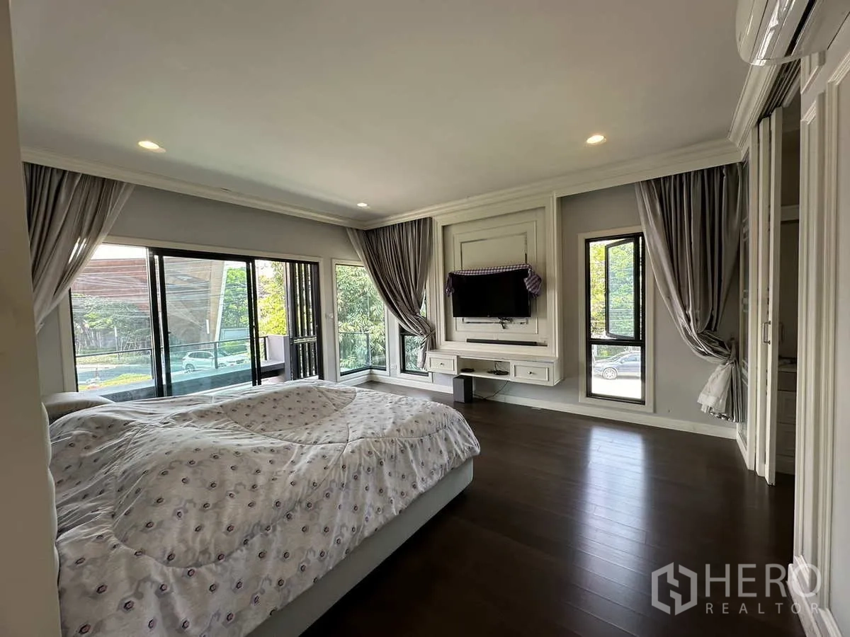 Detached House for rent or sale in Lam Luk Ka, Pathum Thani - Spacious master bedroom with corner windows and TV wall.