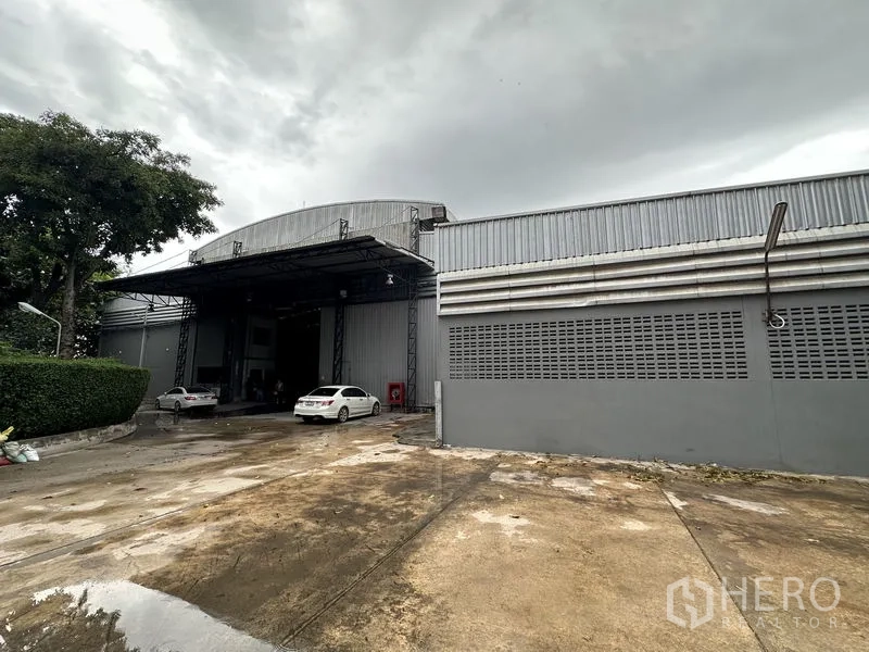 Factory for rent in Bang Bua Thong, Nonthaburi - Side view of the factory exterior and spacious truck-access driveway.