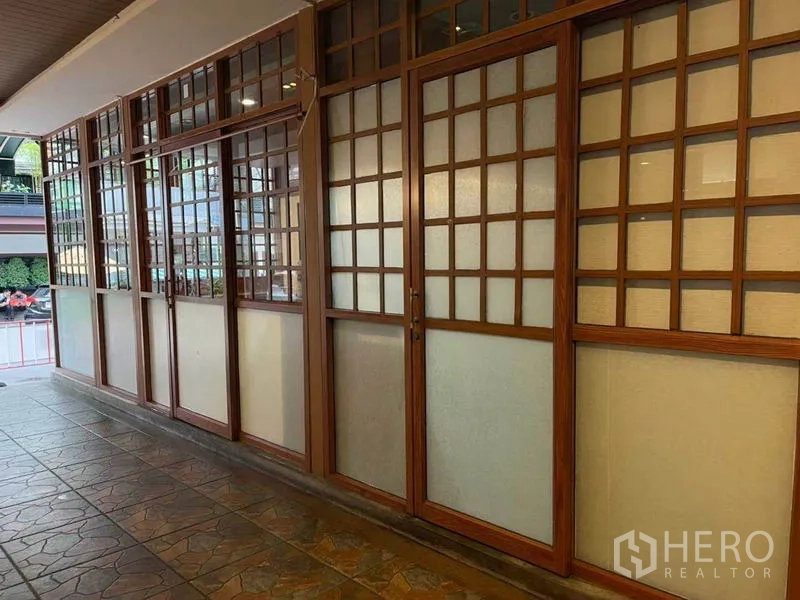 Retail Space for rent in Watthana, Bangkok - Street-facing facade with frosted glass and wooden lattice doors lining the pedestrian walkway.