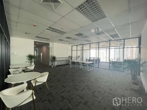 Office Space for rent in Bang Kapi, Bangkok - Open-plan office with lounge tables, potted plants, glass-walled meeting area, and city views.