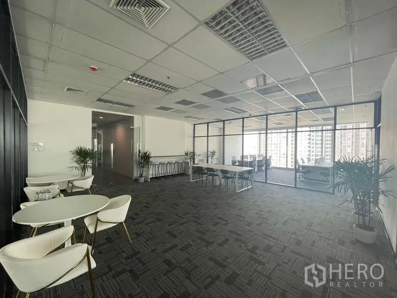 办公空间 出租在Bang Kapi, Bangkok - 开放式办公室，休闲圆桌、绿植、玻璃墙会议区与城市景观。