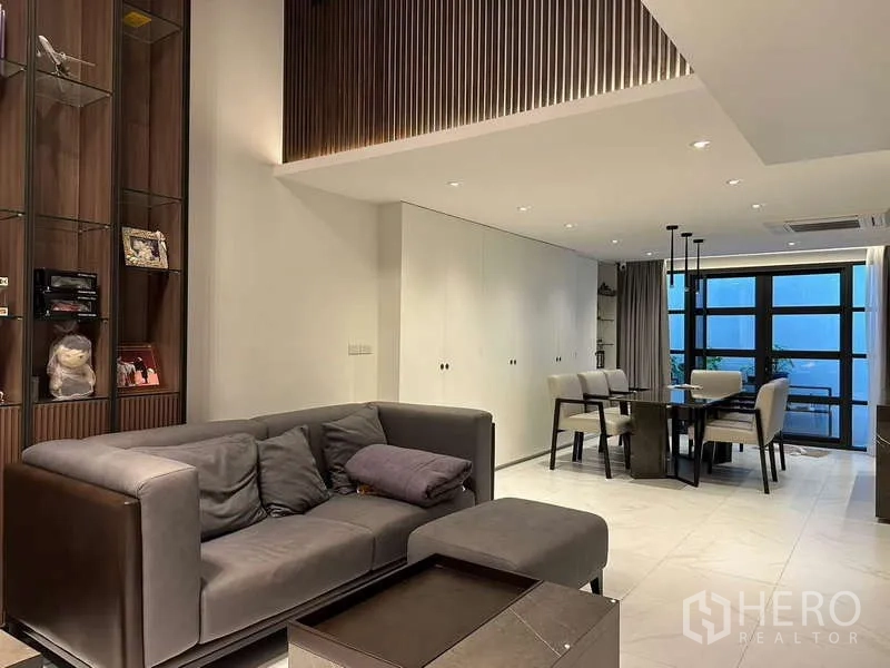 Townhouse for rent in Yan Nawa, Bangkok - Bright dining zone adjoining living area with large windows and curtains.