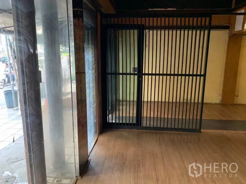อาคารพาณิชย์ ให้เช่าในWatthana, Bangkok - มุมทางเข้าโชว์หน้าต่างกระจกเต็มสูงและประตูเหล็กเลื่อนรักษาความปลอดภัยสีดำ