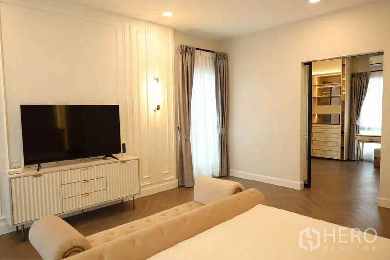 Detached House for rent or sale in Saphan Sung, Bangkok - Spacious bedroom with TV console and entrance to walk-in closet.