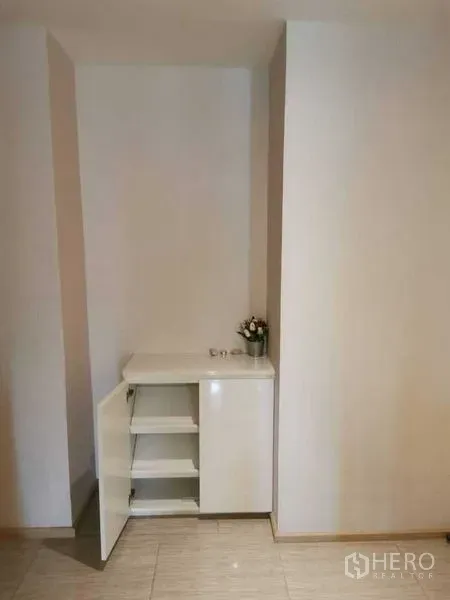 Condominium for rent or sale in Watthana, Bangkok - Built-in storage cabinet with shelves in the entry nook.