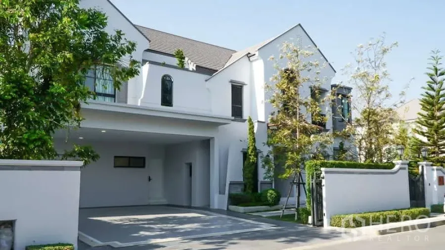 Detached House for rent in Saphan Sung, Bangkok - Front elevation of the detached house with gated entrance and mature trees.