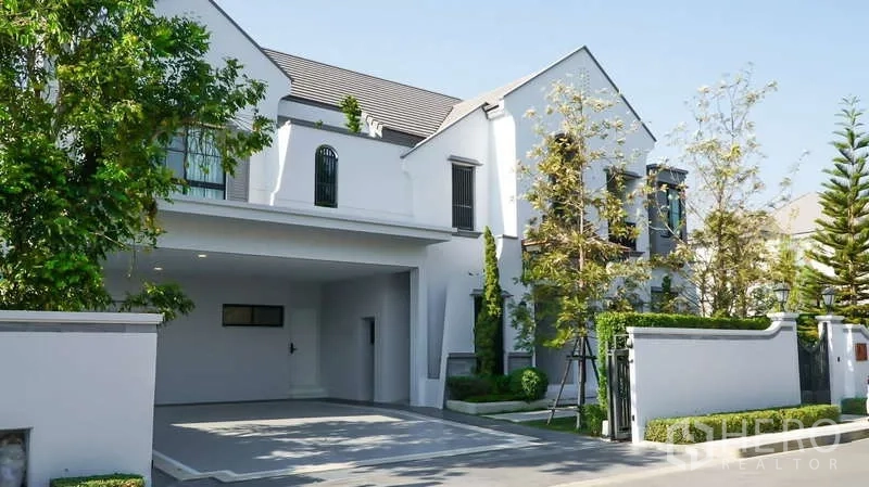 Detached House for rent in Saphan Sung, Bangkok - Front elevation of the detached house with gated entrance and mature trees.