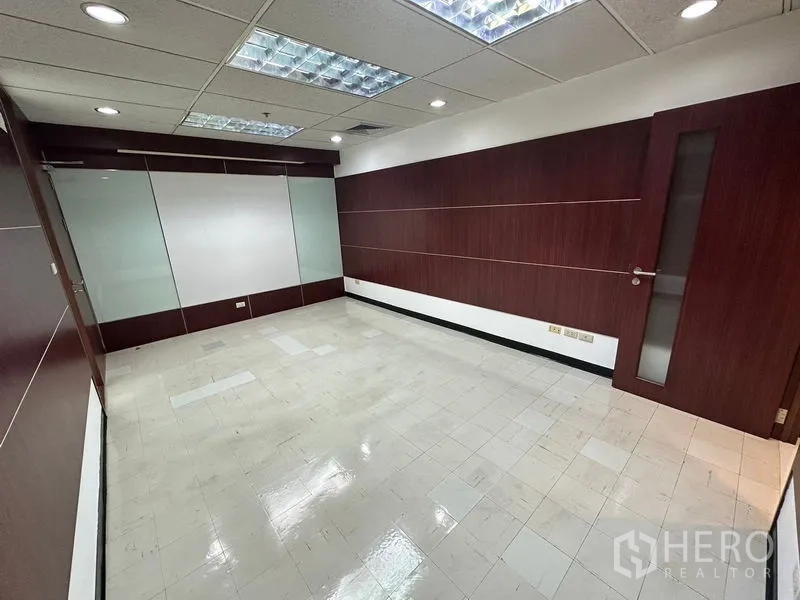 Office Space for rent in Chatuchak, Bangkok - Meeting room with wood-paneled walls and a glass sliding partition.