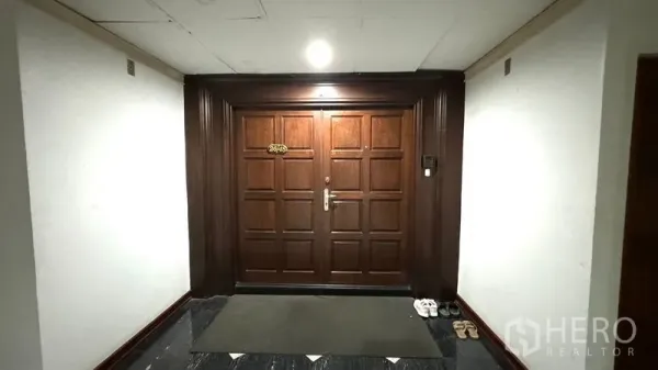 Condominium for rent or sale in Watthana, Bangkok - Entrance corridor with solid wooden double doors to the condominium unit.