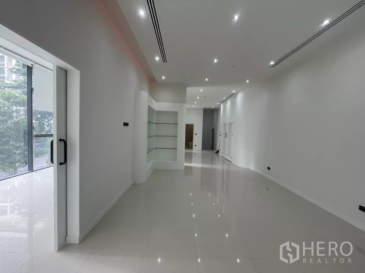 零售空间 出租 - 开放式展厅，带阳台门与内置陈列架。
