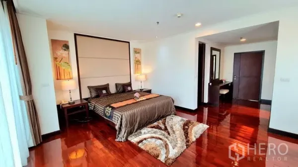 Apartment for rent in Watthana, Bangkok - Spacious master bedroom with polished wood floors, large headboard wall and ensuite access.
