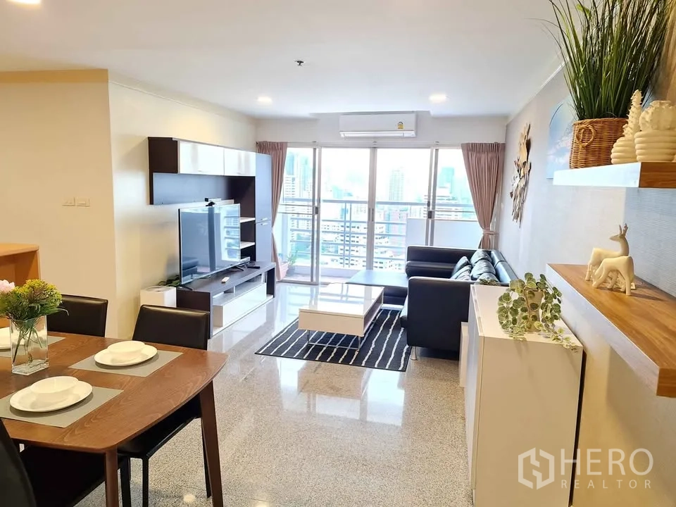 คอนโด for rent in Khlong Toei, Bangkok - ห้องนั่งเล่นพร้อมชั้นวางทีวี โซฟา และทางออกสู่ระเบียง.