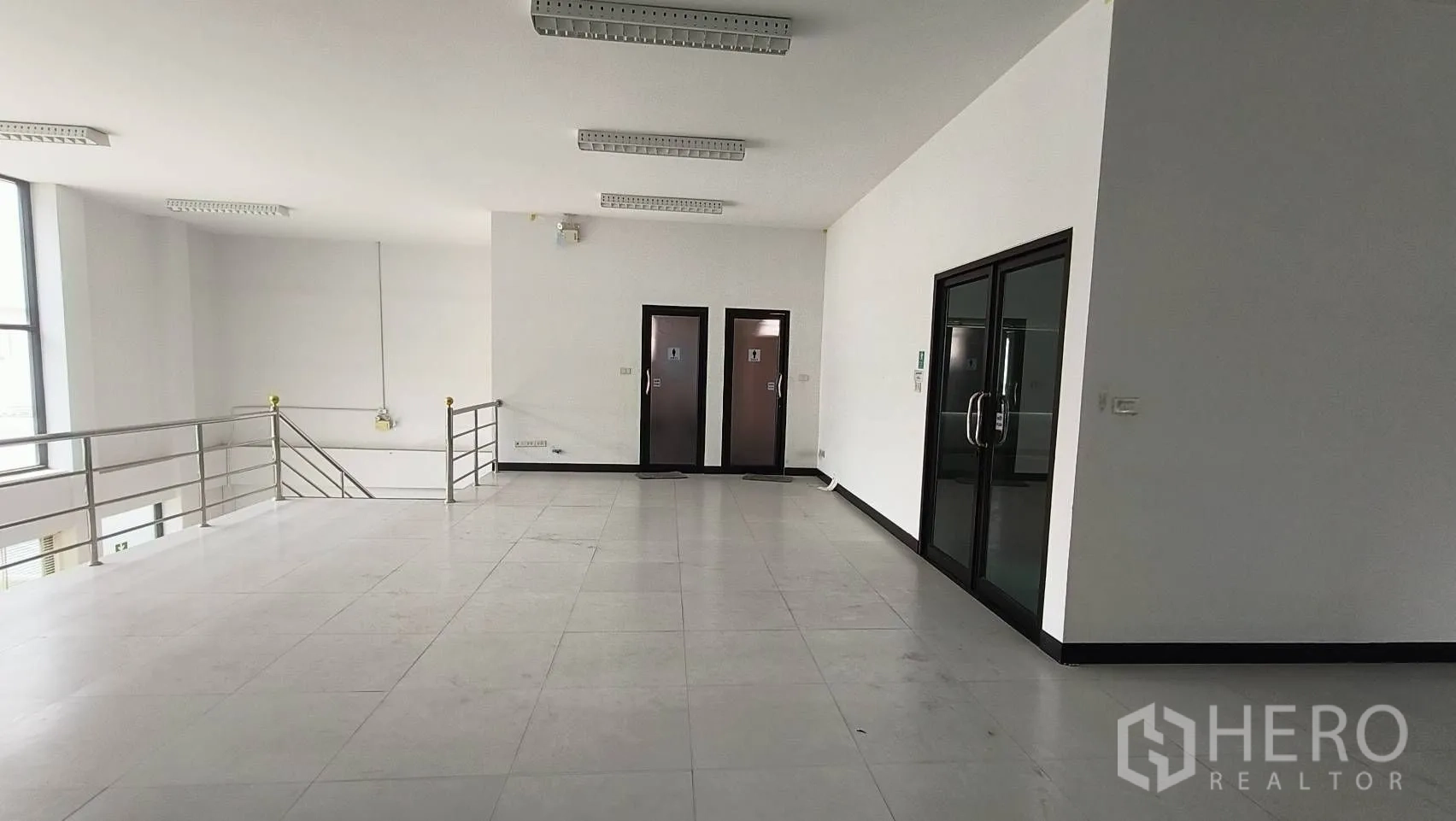 办公空间 出租在Khlong Toei, Bangkok - 夹层平台，两扇卫生间门与玻璃办公室入口。