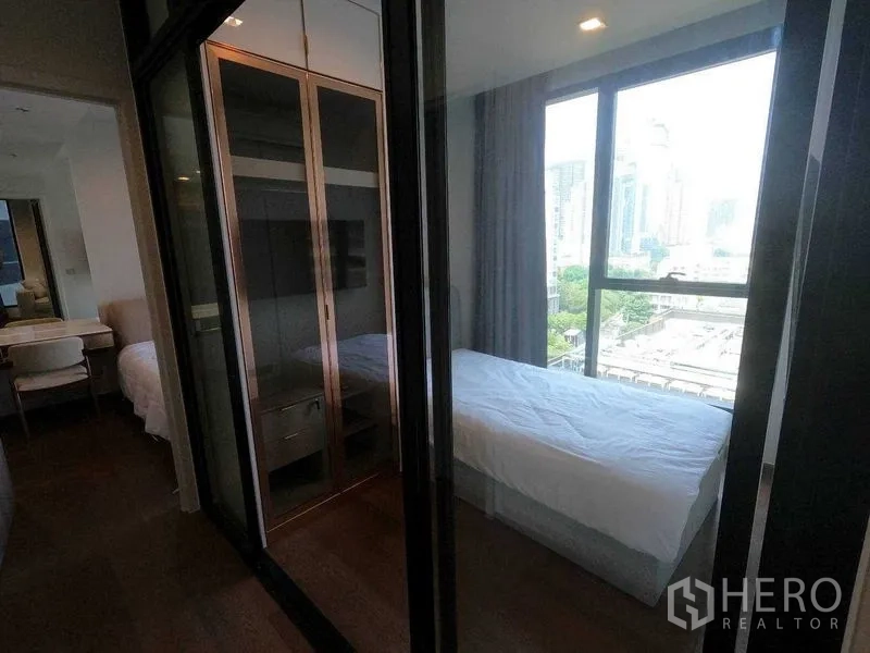 公寓 出租在Khlong Toei, Bangkok - 次卧配单人床、玻璃衣柜与全景窗，光线充足。