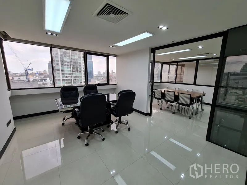 Office Space for rent in Bang Rak, Bangkok - Executive area with leather chairs and a small meeting table beside a glass-walled boardroom.