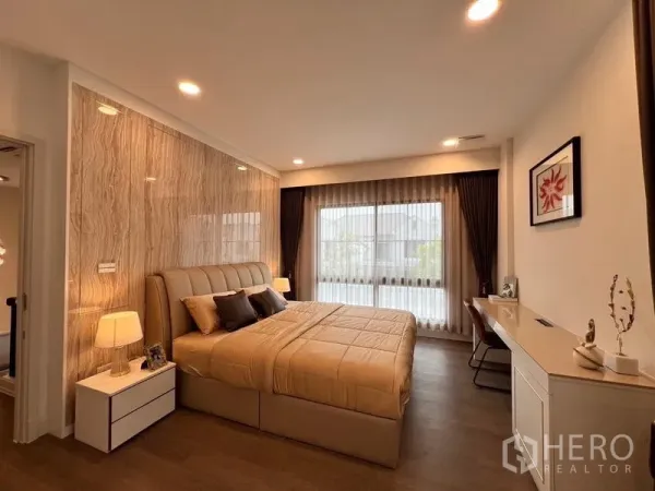 Detached House for rent or sale in Saphan Sung, Bangkok - Warm master bedroom with padded headboard, large window and bedside tables.