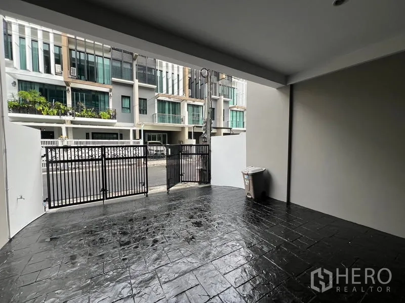 联排别墅 出租或出售在Khlong Toei, Bangkok - 带顶车位与黑色栅栏门，临安静联排小街。