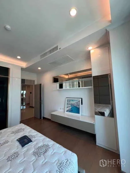 公寓 出租在Ratchathewi, Bangkok - 卧室特色墙搭配悬浮层板与镜面柜体，简约时尚。