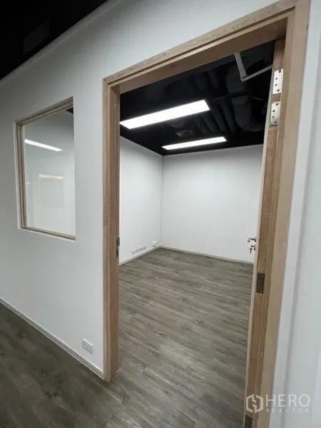 Office Space for rent in Khlong Toei, Bangkok - Doorway to another office room with interior window and ceiling ducts.