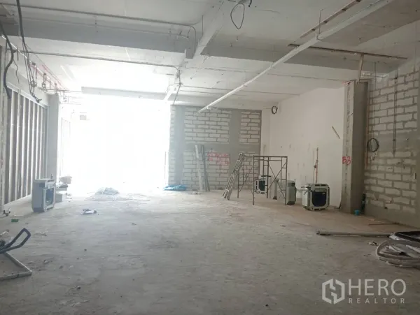 零售空间 出租 - 进深空间，入口自然采光，带脚手架与梯子。