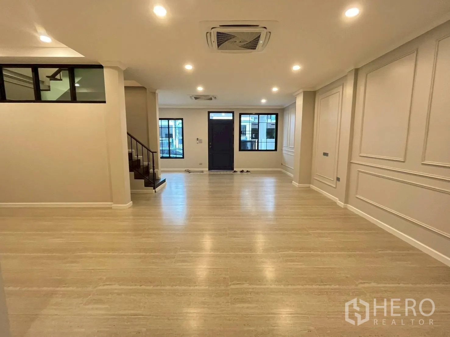 联排别墅 for rent in Khlong Toei, Bangkok - 宽景客厅，嵌入式照明、线条装饰墙与入户门。