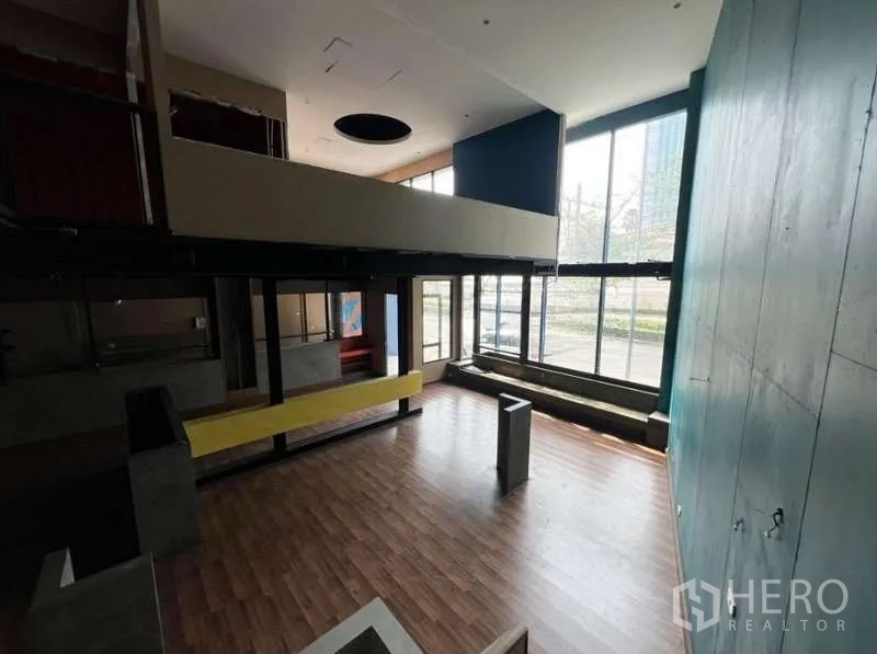 Retail Space for rent in Phaya Thai, Bangkok - Double-height showroom space with mezzanine, wood flooring and full-height windows facing the street.