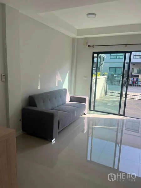 Townhouse for rent in Suan Luang, Bangkok - Modern three-storey townhouse facade with large windows and gated front yard.