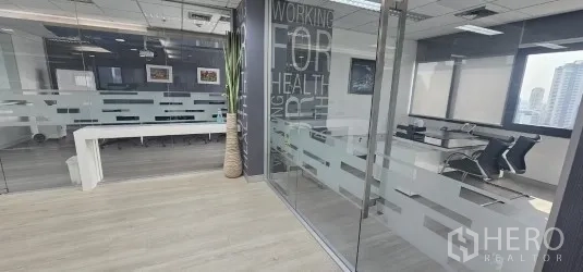 Office Space for rent in Bang Rak, Bangkok - Silom office space interior with glass-walled meeting room, frosted partitions, light wood floors and city views.