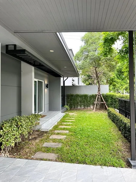 独立式住宅 出售在Prawet, Bangkok - 前庭草坪设踏步石、绿篱和带顶门廊。