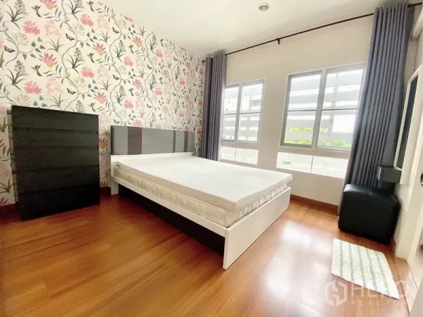 联排别墅 出租在Prawet, Bangkok - 明亮次卧，花卉壁纸，双人床与成排窗户
