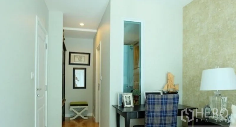 Condominium for rent in Khlong Toei, Bangkok - Hallway with desk nook, mirrors, and a door to the bathroom in a modern one-bedroom unit.