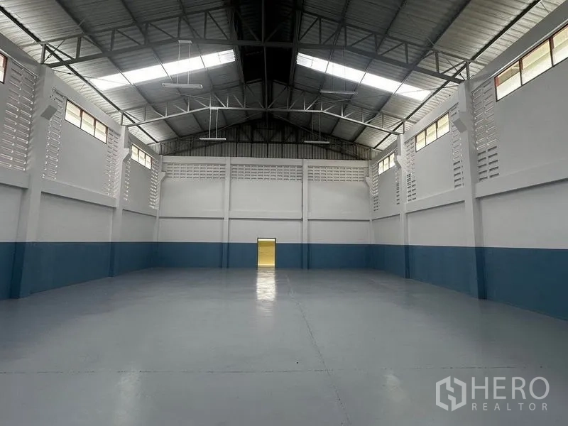 Factory for rent in Pathum Thani - Warehouse rear wall view with tall vents and epoxy-coated floor.
