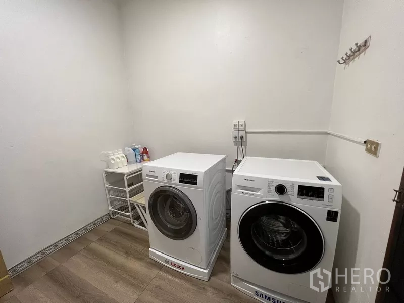 Townhouse for rent or sale in Suan Luang, Bangkok - Laundry room with separate washer and dryer and storage rack.
