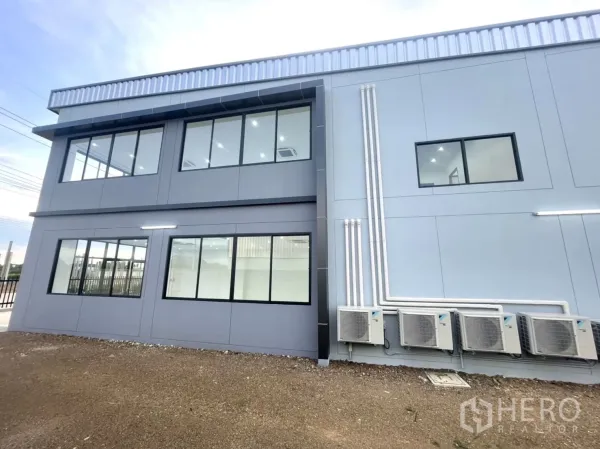 Factory for rent or sale in Bang Yai, Nonthaburi - Side elevation with large windows and outdoor AC compressor units.