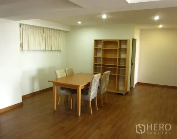 Condominium for rent or sale in Watthana, Bangkok - Dining area with wooden flooring, four-seat table, and built-in shelving.