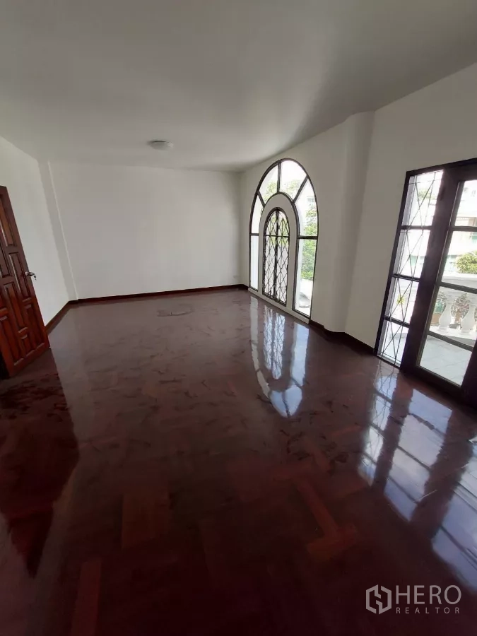 Home Office for rent in Yan Nawa, Bangkok - Expansive office lounge with arched windows opening to a balcony.