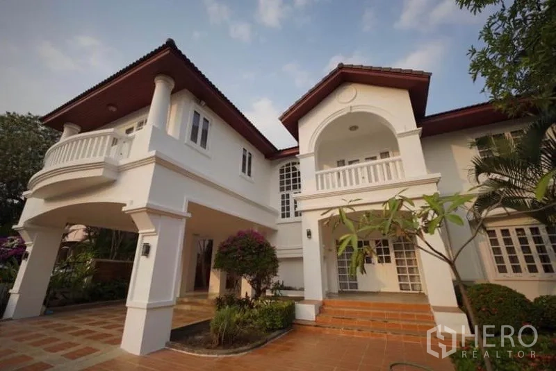 บ้าน ให้เช่าในBang Phli, Samut Prakan - ด้านหน้าบ้านเดี่ยวสองชั้น ระเบียงโค้ง พร้อมเฉลียงและสวนตกแต่ง