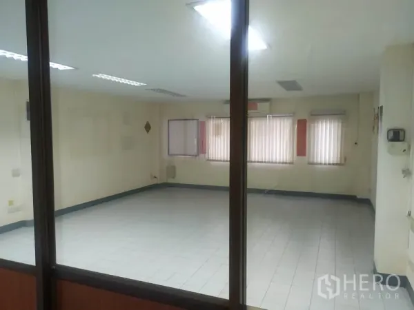 带办公室的家 出租在Yan Nawa, Bangkok - 通过玻璃隔断看到的宽敞空房，带窗户与百叶帘。
