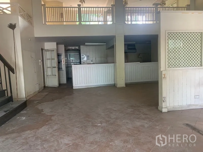 Shophouse for rent in Watthana, Bangkok - Open area with white service counter below a mezzanine railing.
