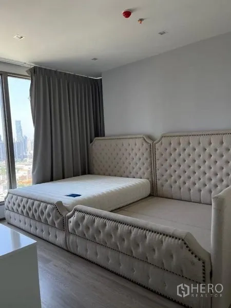 Condominium for rent in Bang Kho Laem, Bangkok - Spacious bedroom with twin upholstered bed frames and skyline view.