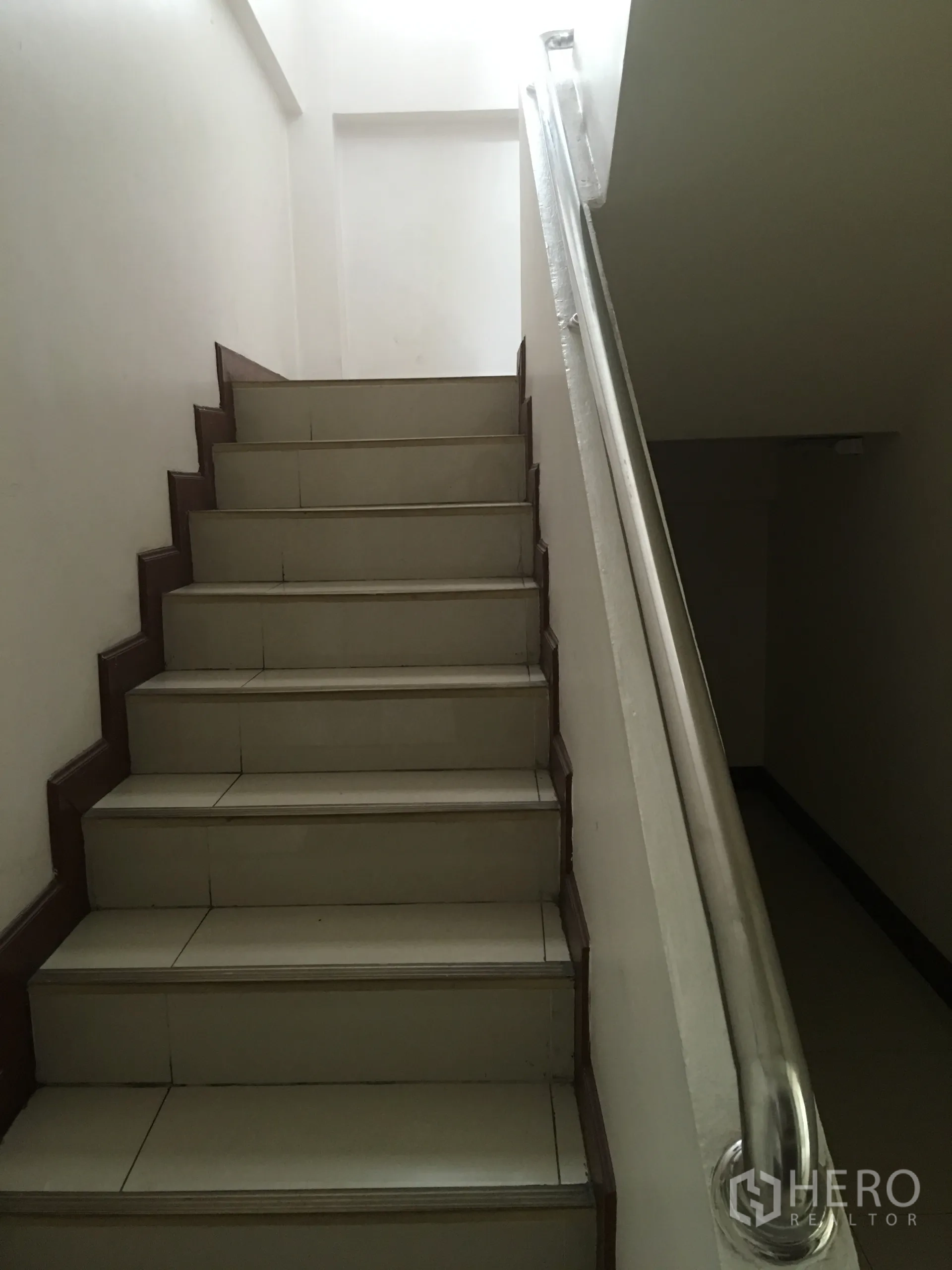 联排别墅 出租在Khlong Toei, Bangkok - 室内楼梯，瓷砖踏步与金属扶手通往二层