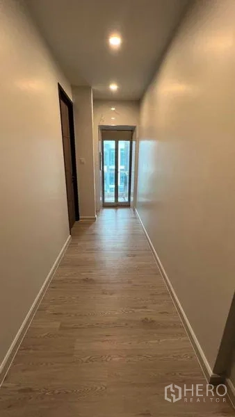 Home Office for rent - Long hallway with wood flooring leading to a glass lift and balcony doors.