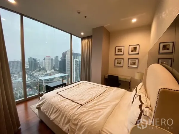 Condominium for rent in Khlong Toei, Bangkok - Master bedroom with floor-to-ceiling windows showcasing a panoramic Bangkok city view.