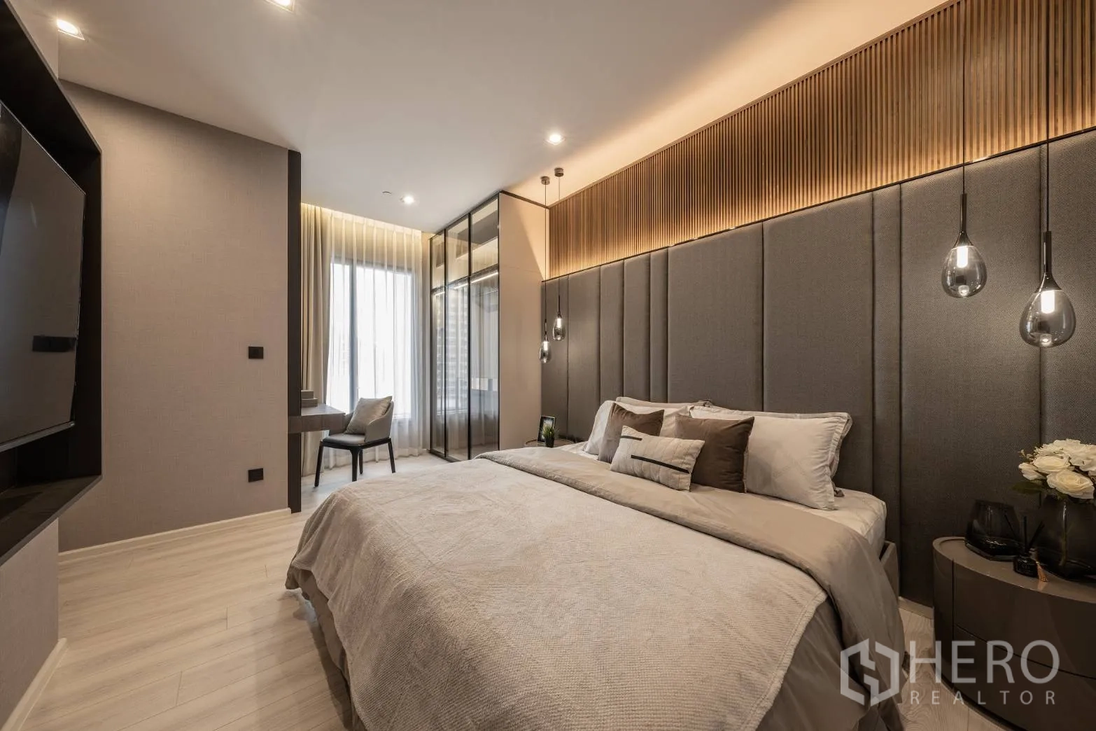 公寓 出售在Ratchathewi, Bangkok - 宽敞主卧，软包床头、吊灯与窗边书桌。