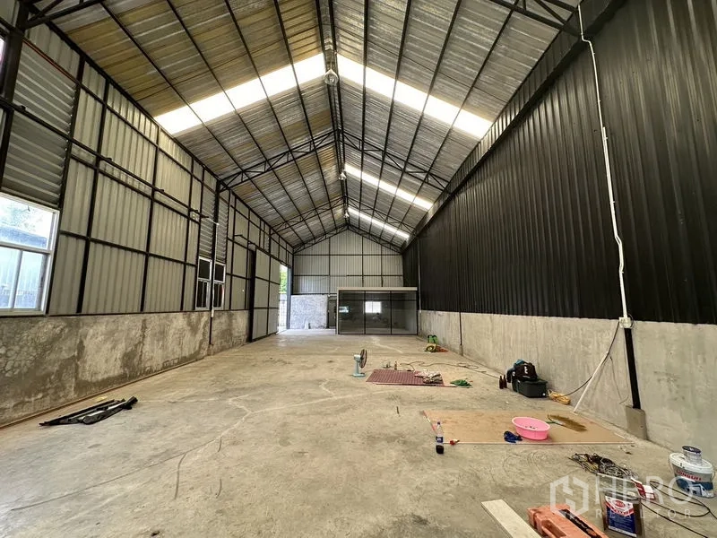 Warehouse for rent in Lat Phrao, Bangkok - Long interior aisle with windows and a glass office at the far end.