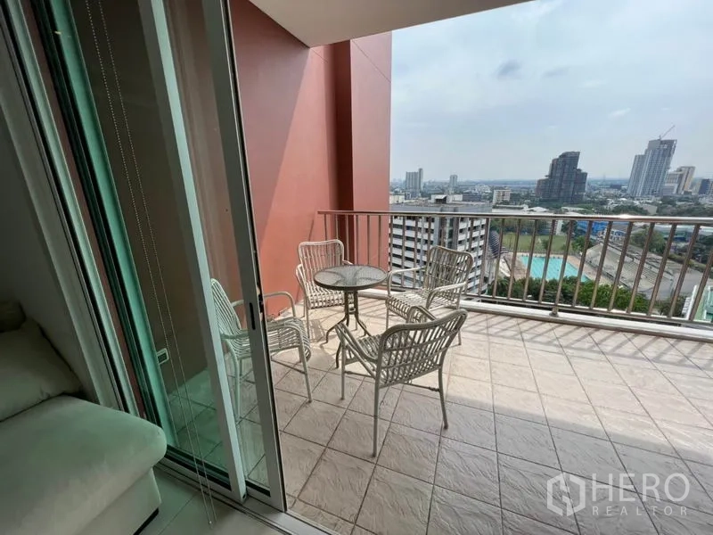 公寓 出租在Watthana, Bangkok - 客厅外的阳台，推拉玻璃门与护栏，远眺城市景观。